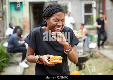 African American Woman eating at backyard barbecue Banque D'Images