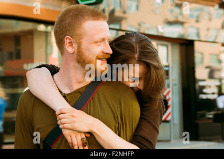 Caucasian couple hugging on city sidewalk Banque D'Images