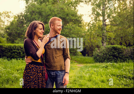 Caucasian couple hugging in field Banque D'Images