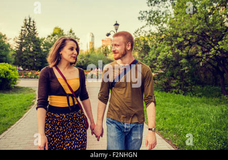 Caucasian couple holding hands in park Banque D'Images