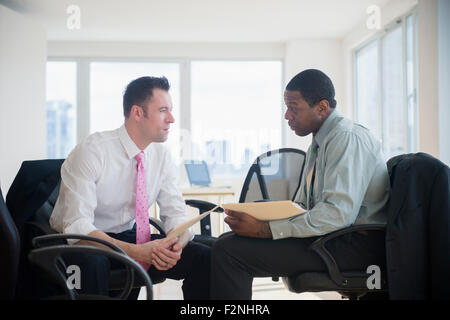 Hommes d'holding folders in office Banque D'Images