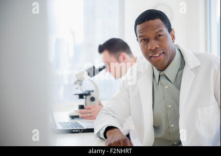 Scientist sitting at table in lab Banque D'Images