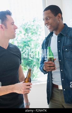 Les hommes de boire une bière près de window Banque D'Images