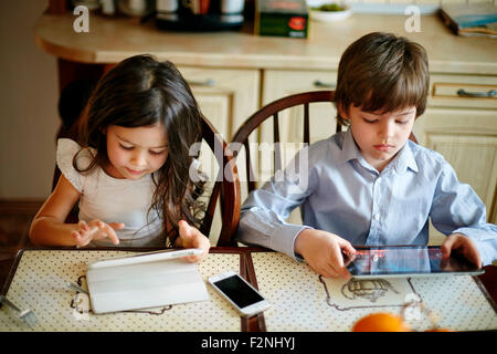 Frère et soeur de race blanche à l'aide de tablettes numériques Banque D'Images