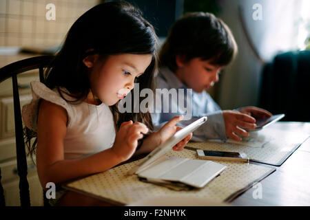 Frère et soeur de race blanche à l'aide de tablettes numériques Banque D'Images