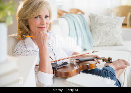 Caucasian woman holding violin sur canapé Banque D'Images