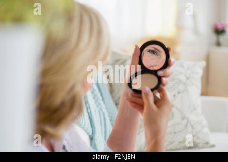 Caucasian woman admiring Herself in mirror Banque D'Images