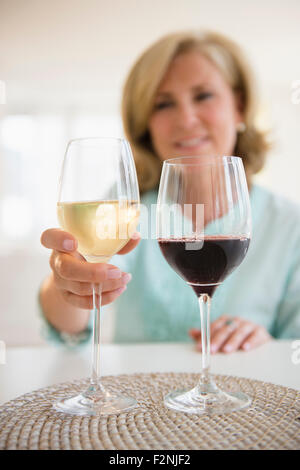 Caucasian woman choisir le vin blanc et le vin rouge Banque D'Images