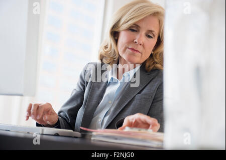 Caucasian businesswoman working in office Banque D'Images