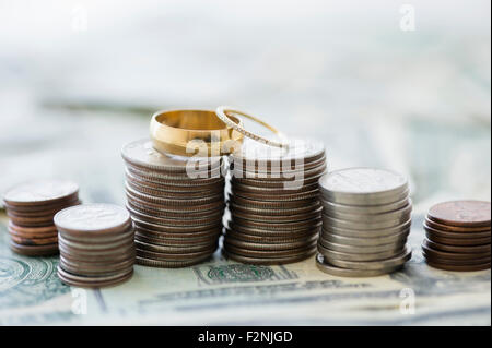 Close up de piles de pièces de monnaie et les anneaux de mariage Banque D'Images