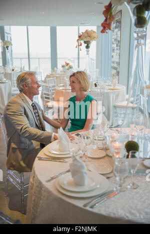 Caucasian couple talking in empty restaurant Banque D'Images