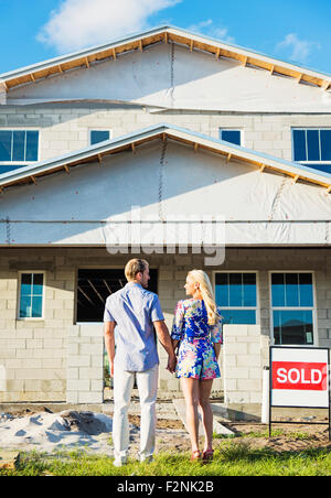 Caucasian couple admiring new home Banque D'Images