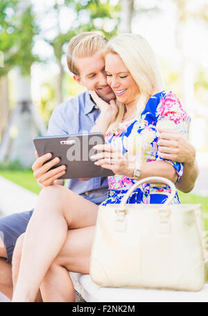 Caucasian couple sitting on bench Banque D'Images