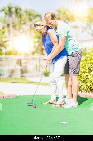 Caucasian couple playing miniature golf Banque D'Images