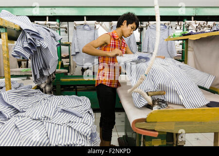 Travailleur asiatique chemise repassage en garment factory Banque D'Images