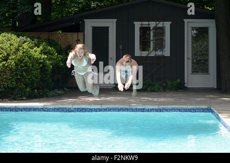 Couple de plonger dans une piscine dans la cour Banque D'Images