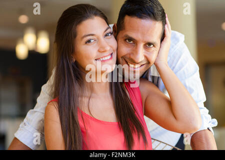 Close up of smiling Hispanic couple hugging Banque D'Images