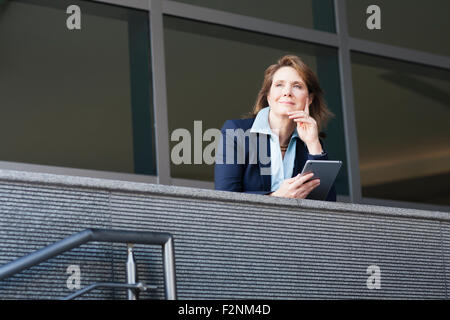 Caucasian businesswoman using digital tablet sur balcon Banque D'Images