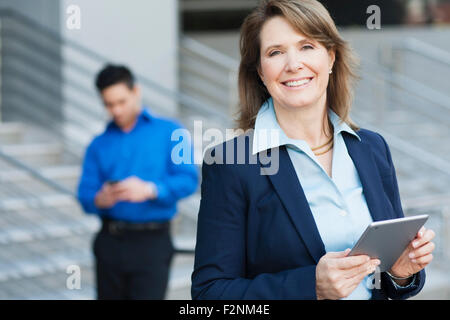 Businesswoman using digital tablet near staircase Banque D'Images