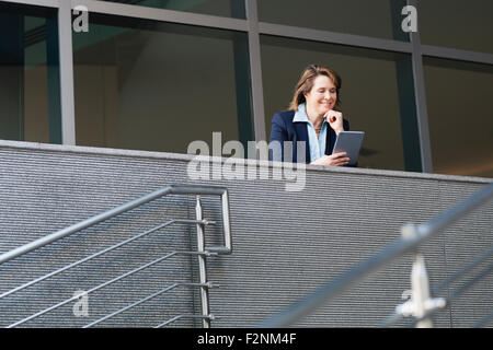 Caucasian businesswoman using digital tablet sur balcon Banque D'Images