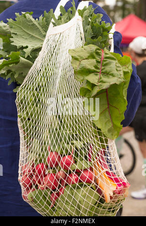 African American man carrying bag de produire au cours du marché Banque D'Images