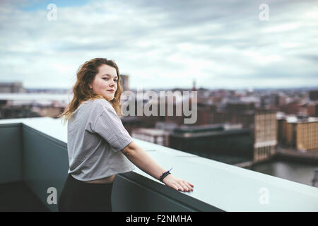 Caucasian woman on urban rooftop admirant cityscape Banque D'Images