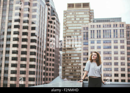 Caucasian woman on urban rooftop admirant cityscape Banque D'Images