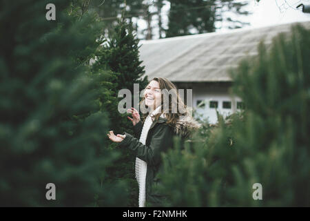 Caucasian woman walking dans beaucoup d'arbres de Noël Banque D'Images