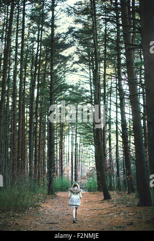 Caucasian woman walking on dirt path in forest Banque D'Images