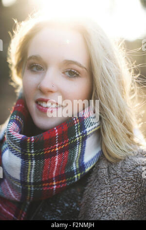 Smiling Caucasian woman wearing plaid écharpe Banque D'Images