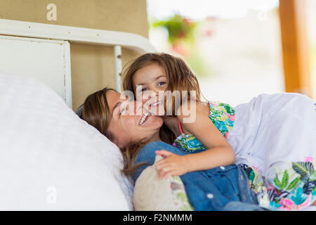 Mother and Daughter hugging on bed Banque D'Images