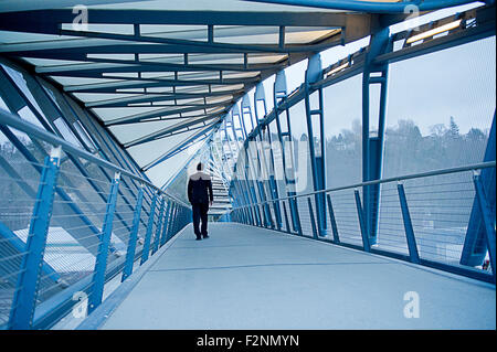 Caucasian businessman walking sur pont en ciel Banque D'Images