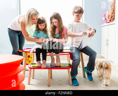 Caucasian family dessin à table dans une salle de jeux Banque D'Images