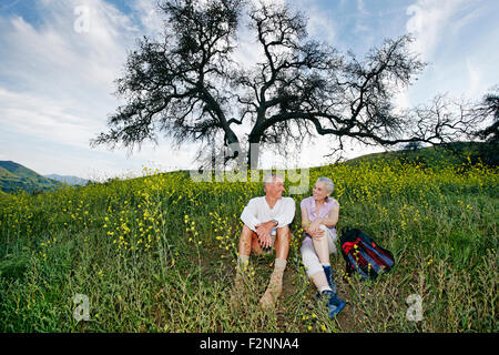 Caucasian couple sitting in tall grass Banque D'Images