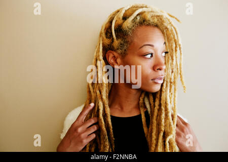 Femme noire avec des dreadlocks looking away Banque D'Images