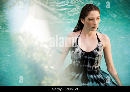 Caucasian woman wearing dress in swimming pool Banque D'Images