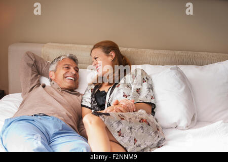 Laughing couple relaxing on bed Banque D'Images