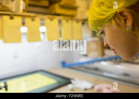 Caucasian artist travaillant dans l'atelier d'impression écran Banque D'Images