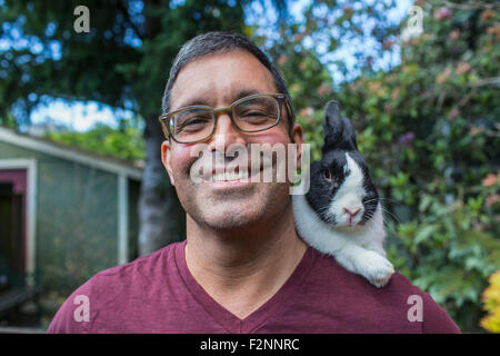 Mixed Race man carrying lapin sur l'épaule Banque D'Images