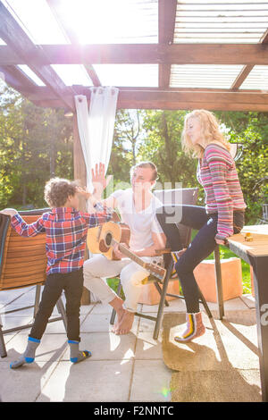 Père et fils haut-fiving sur patio dans L Banque D'Images