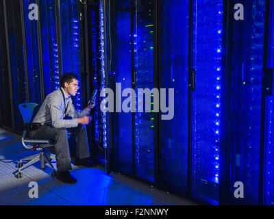 Hispanic technicien travaillant dans la salle des serveurs Banque D'Images
