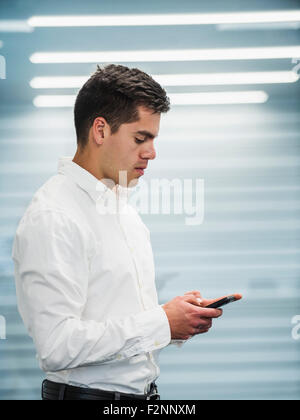 Hispanic businessman using cell phone in office Banque D'Images