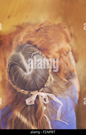 Caucasian girl hugging dog Banque D'Images