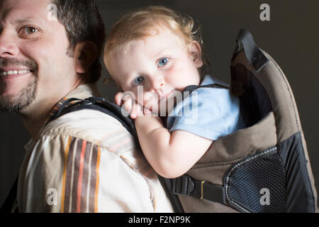 Woman carrying son on retour Banque D'Images