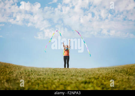 Caucasian girl Playing with ribbons sur colline Banque D'Images