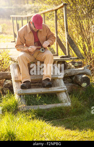 Caucasian man loading canne à pêche sur les mesures Banque D'Images