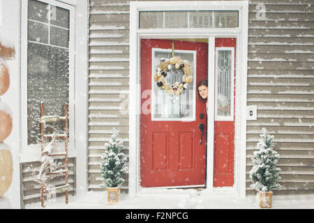Femme de race blanche de l'ouverture de la porte à la neige Banque D'Images