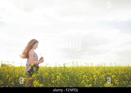 Caucasian teenage Girl standing in field of flowers Banque D'Images