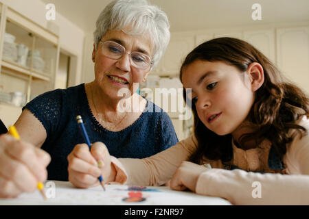 Grand-mère et sa petite-fille à la table de dessin Banque D'Images