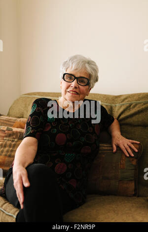 Older woman sitting on sofa Banque D'Images